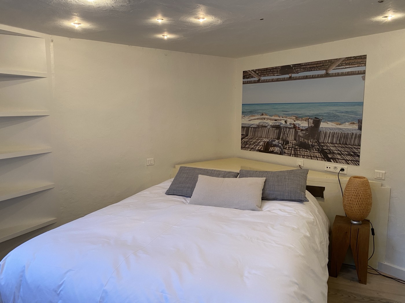 Bed with art on the wall in Suite Côté Sud
